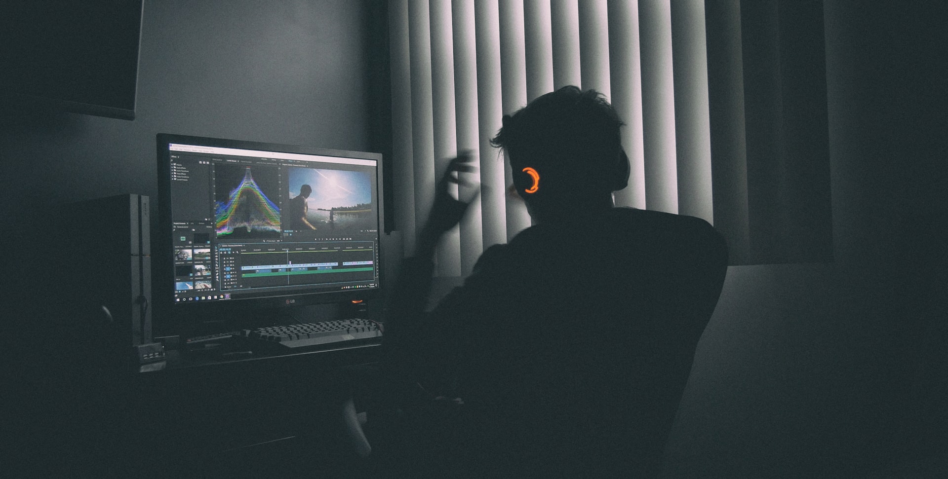 shallow focus photography of man listing to music in front of the computer